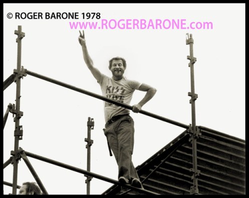 Philadelphia Stagehand Franny O'Shea extends the victory/peace symbol while assembling the Rolling Stones sound towers at JFK Stadium (6/17/1978) © roger barone 1978