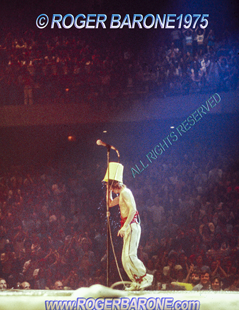 Mick Jagger pouring bucket of water on his head. Spectrum Arena © roger barone 1975