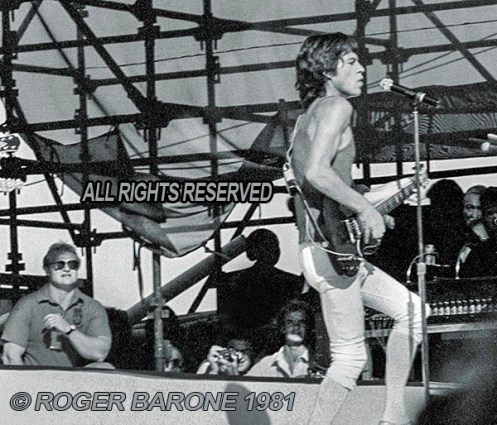 Rolling Stones' security team member, Bob Bender, watching over Mick Jagger. Philly, (9/25/81) © Roger Barone